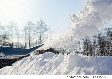 Shovelling snow in sunny winter day. Removing snow from driveway Shovelling snow in sunny winter day. Removing snow from driveway 133454899