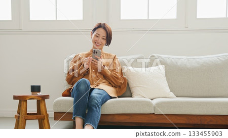 Woman operating a mobile phone Woman operating a mobile phone 133455903