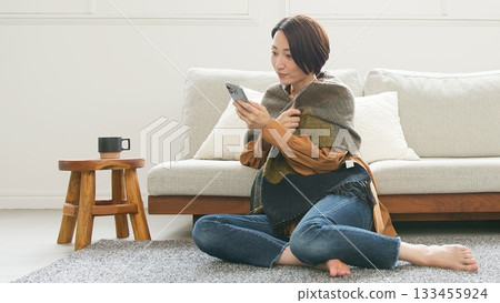 Woman operating a mobile phone Woman operating a mobile phone 133455924