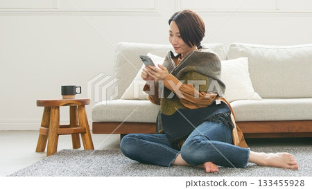 Woman operating a mobile phone 133455928