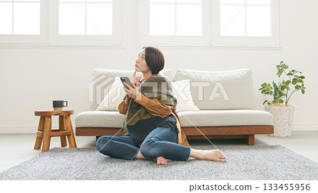 Woman operating a mobile phone 133455956