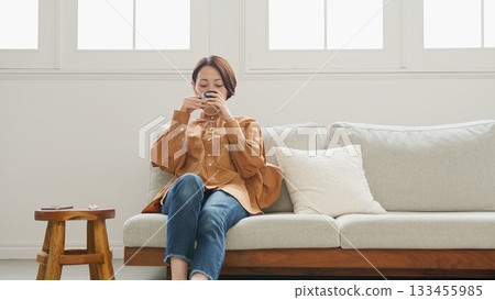 Woman operating a mobile phone Woman operating a mobile phone 133455985