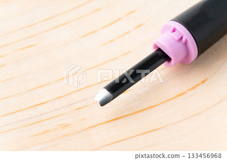 Close-up of the back of the cutting edge of a small round chisel (small round chisel) and a wooden board 133456968