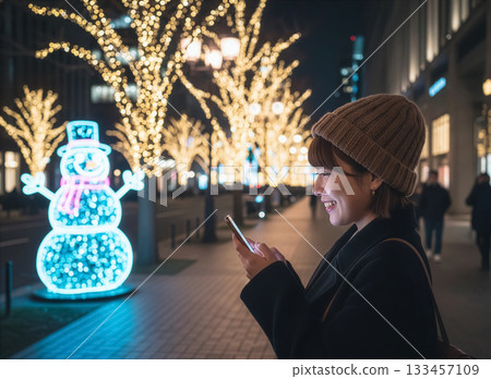 Woman looking at smartphone, illuminations, outdoors Woman looking at smartphone, illuminations, outdoors 133457109