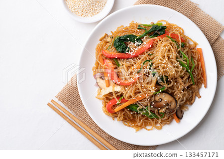 Japchae, Korean stir fried glass noodles with vegetables, pork, soy sauce and sesame oil Japchae, Korean stir fried glass noodles with vegetables, pork, soy sauce and sesame oil 133457171
