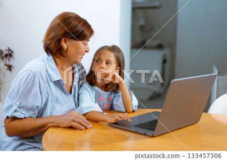 Grandmother and granddaughter using laptop Grandmother and granddaughter using laptop 133457306