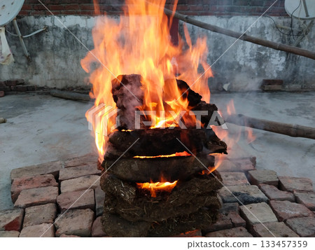 cow dung cakes are being burnt for making Indian dish Bati-Chokha. Cow dungs are being burnt outdoor 133457359