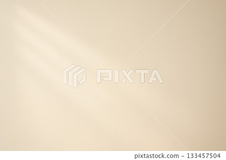 Pale beige wall texture background illuminated by soft morning light 133457504