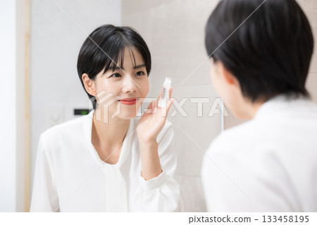 一位微笑的女士正在用卸妝產品護理皮膚(卸妝),展示了清潔和卸妝的場景。 一位微笑的女士正在用卸妝產品護理皮膚(卸妝),展示了清潔和卸妝的場景。 133458195