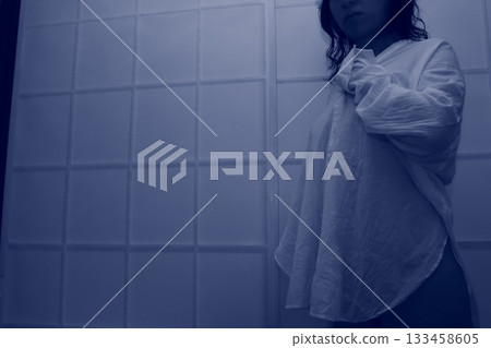 房間裡，一個女人靠在牆上。 133458605
