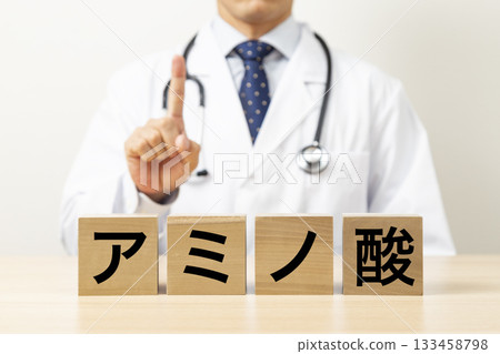 A block with the word "amino acid" written on it and a doctor A block with the word "amino acid" written on it and a doctor 133458798