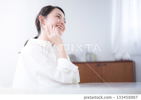 A beauty portrait of a young woman in a white shirt with a clean look, smiling and showing skin care and beautiful skin A beauty portrait of a young woman in a white shirt with a clean look, smiling and showing skin care and beautiful skin 133458907