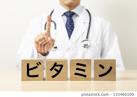 A block with the word "vitamin" written on it and a doctor 133460100