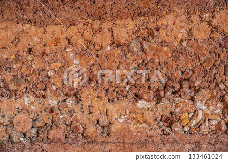 Full frame shot of rough earthen wall texture. These walls are constructed by ramming a mixture of aggregates, including gravel, sand, silt and a small amount of clay. 133461024