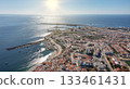 sines portugal. sunset over calm coastal area featuring leisure activities and vessels, vivid aerial depiction of tranquil sines bay with sandy shores and boating 133461431