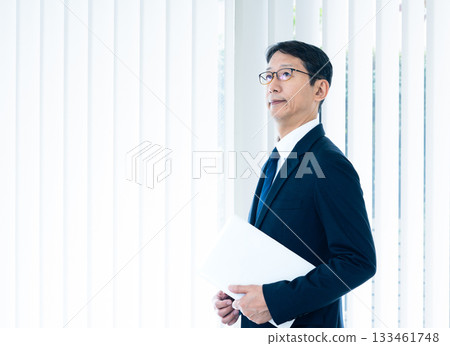 A businessman standing at the window 133461748
