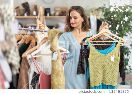 Young woman choosing tank tops in a store Young woman choosing tank tops in a store 133461835