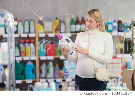 Interested pregnant woman choosing safe laundry detergent in store Interested pregnant woman choosing safe laundry detergent in store 133461854