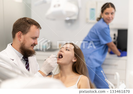 Woman checking her teeth at a dentist appointment Woman checking her teeth at a dentist appointment 133461870