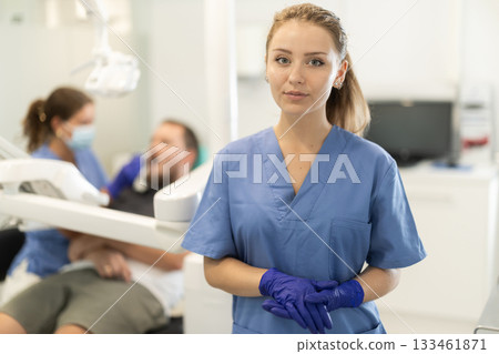 Female dental assistant standing in front of the office 133461871
