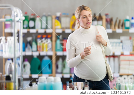 Interested pregnant woman choosing home care products in store Interested pregnant woman choosing home care products in store 133461873