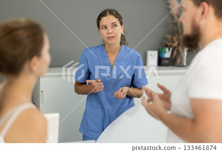 female administrator communicates with clients of a dental clinic 133461874
