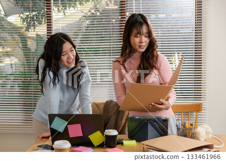 Busy people meet office financial work consult team business, young businesswoman collaborates with colleague at desk, reviewing project documents, planning strategy in modern workspace. 133461966