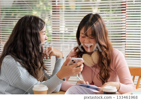 Young busy people meet in office, discussing financial work, consulting as team business colleagues, sharing laughter while reviewing important documents, planning strategies for project success. 133461968