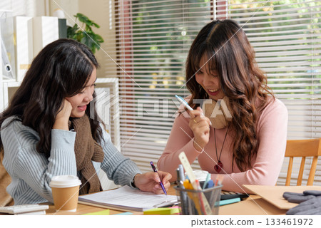 Young businesswomen busy meet, consulting on financial work within office, collaborating for team project, actively discussing strategies, demonstrating dedication, aiming for success. Young businesswomen busy meet, consulting on financial work within office, collaborating for team project, actively discussing strategies, demonstrating dedication, aiming for success. 133461972