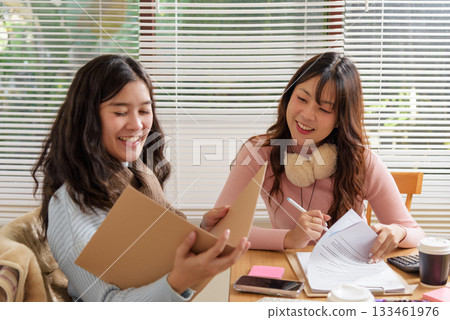 Busy business people meet, work, consult financial team in office, young women collaborate together, analyze documents, foster productive discussion, successful partnership development. 133461976