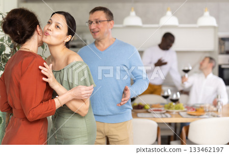 Happy middle-aged pair welcoming a woman at home 133462197