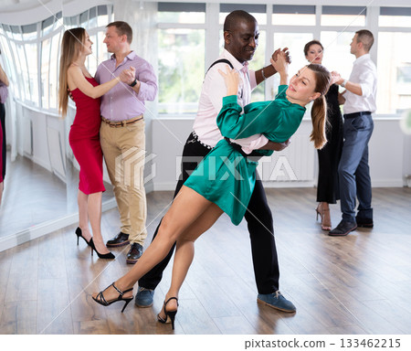 Woman dances incendiary tango with African man partner during choreography lesson 133462215