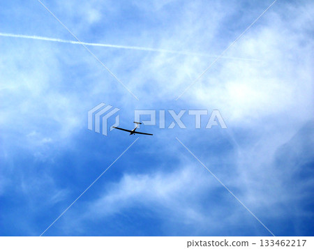 一架小型飛機在藍天白雲間飛行。 133462217