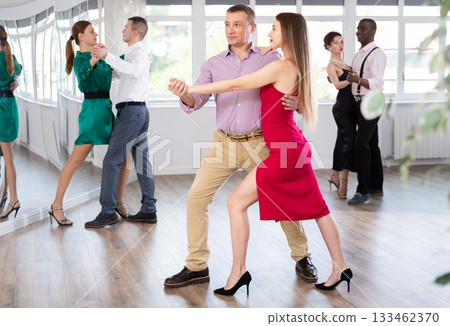 Man and young woman practicing waltz in dancing studio Man and young woman practicing waltz in dancing studio 133462370