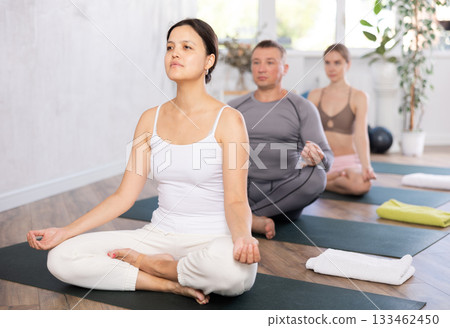 Asian woman meditating in lotus position with hands in mudra Asian woman meditating in lotus position with hands in mudra 133462450