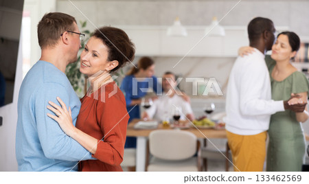 Men and women of different nationalities having fun dancing slow dance at house party 133462569