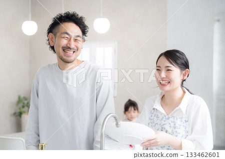 A couple washing dishes in the kitchen. An image of both spouses working. 133462601