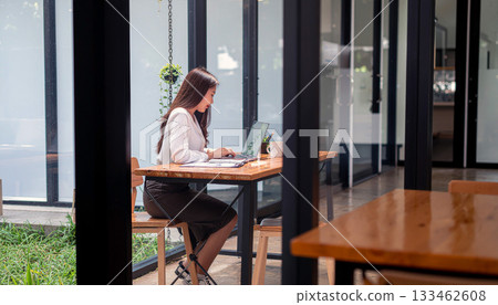 A Japanese office lady starts work at her desk by the window on Monday morning. 133462608