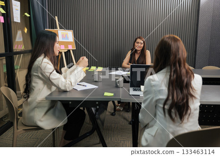 Business women team meet for important project work, busy people collaborate during meeting in modern conference room discussing financial data charts. 133463114