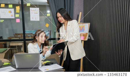 Business women meet, busy team people collaborate on project work, woman partner discusses meeting agenda, analyzing charts for corporate strategy development. 133463178
