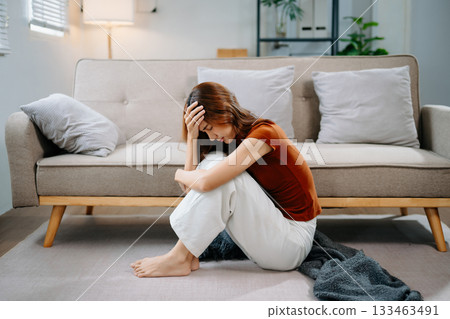 Asian woman sit Depression Dark haired  pensive glance Standing by window and anxiety Copy space. 133463491