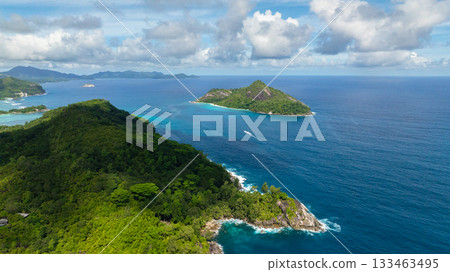 Expansive view of the ocean with two islands surrounded by clear blue waters and clouds. Seychelles, Mahe. 133463495