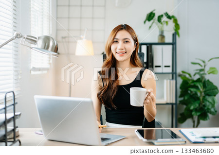 Smiling businesswoman showing thumbs up in bright modern office, symbolizing success, approval, and confidence in professional achievement. Smiling businesswoman showing thumbs up in bright modern office, symbolizing success, approval, and confidence in professional achievement. 133463680
