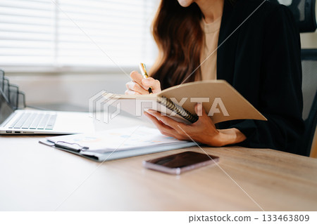 Confident Asian businesswoman presenting chart and data report in modern office. Perfect for marketing, finance, analysis, and professional business strategy concepts. Confident Asian businesswoman presenting chart and data report in modern office. Perfect for marketing, finance, analysis, and professional business strategy concepts. 133463809