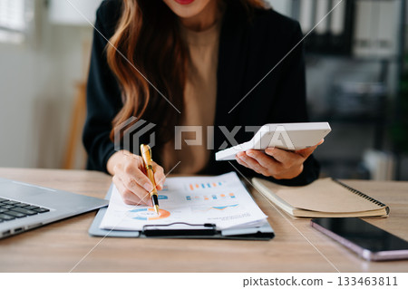 Close up of businesswoman or accountant hand typing laptop working to calculate on desk about cost at home office. 133463811