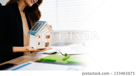 Real estate broker agent presenting and consult to customer to decision making sign insurance form agreement, home model, concerning mortgage loan offer in office 133463873