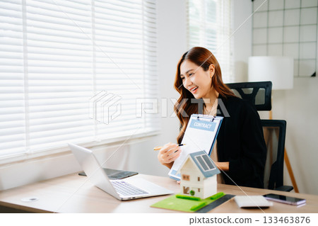 Real estate broker agent presenting and consult to customer to decision making sign insurance form agreement, home model, concerning mortgage loan offer in office 133463876