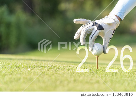 Close up hand Golfer woman putting golf ball for Happy New Year 2026  133463910
