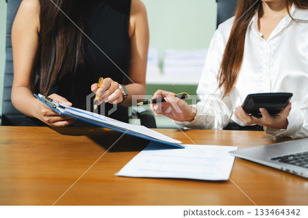Businessman hand using laptop and tablet with social network diagram and two colleagues discussing data on desk as concept Businessman hand using laptop and tablet with social network diagram and two colleagues discussing data on desk as concept 133464342