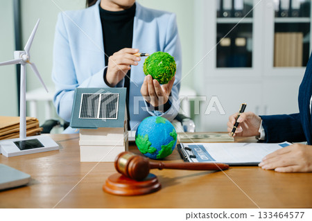 Two professionals plan global sustainability with eco housing, legal contracts, solar energy, and financial investment 133464577